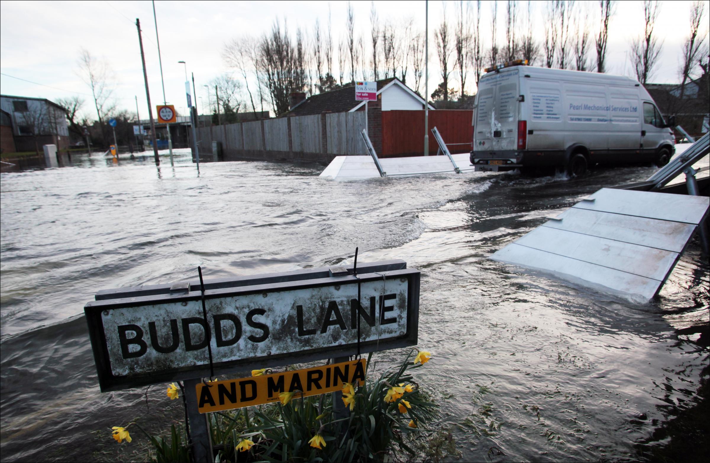 The flooded sign at the end of our road, Budds Lane. Sign reads 'Budds Lane and Marina'.