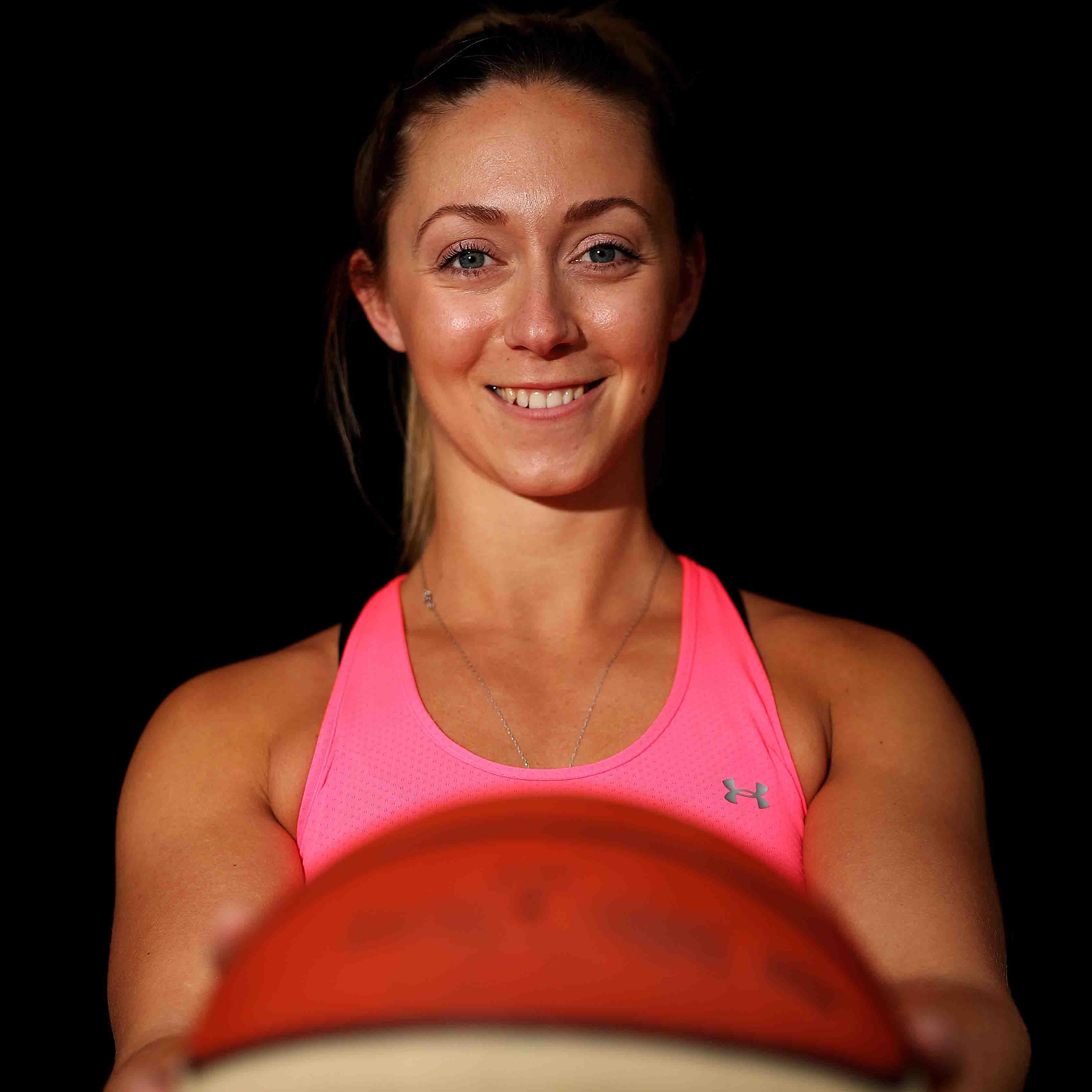 Sophie, smiling and holding a basketball at arms length.